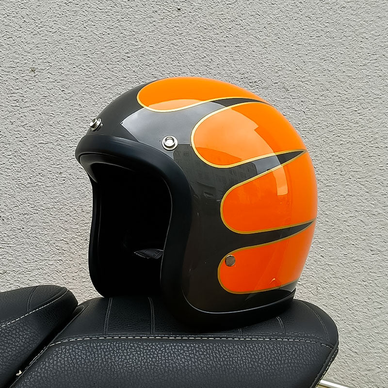 Orange and black motorcycle helmet on a textured gray background