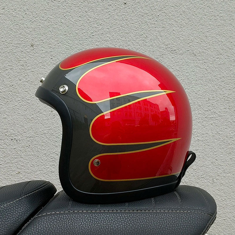 Red and black helmet with gold accents on a gray surface