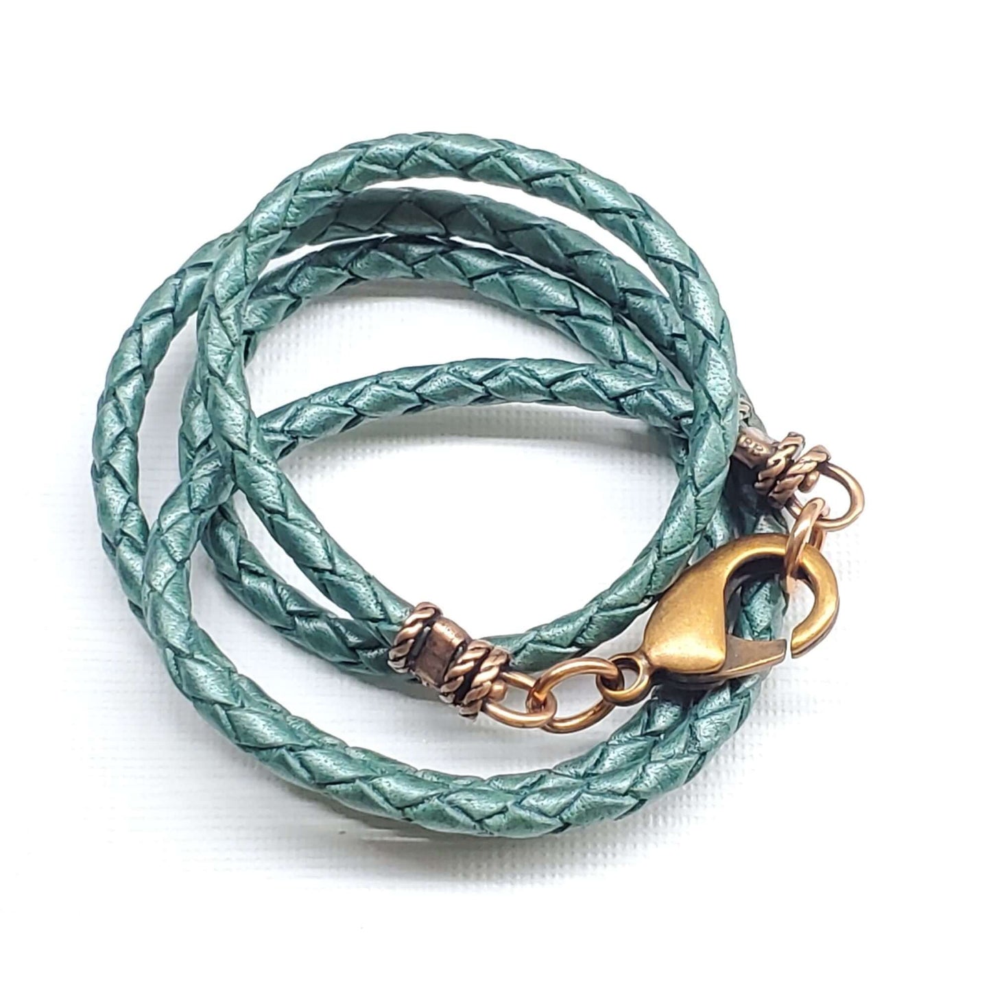 Green braided leather necklace with gold clasp on a white background