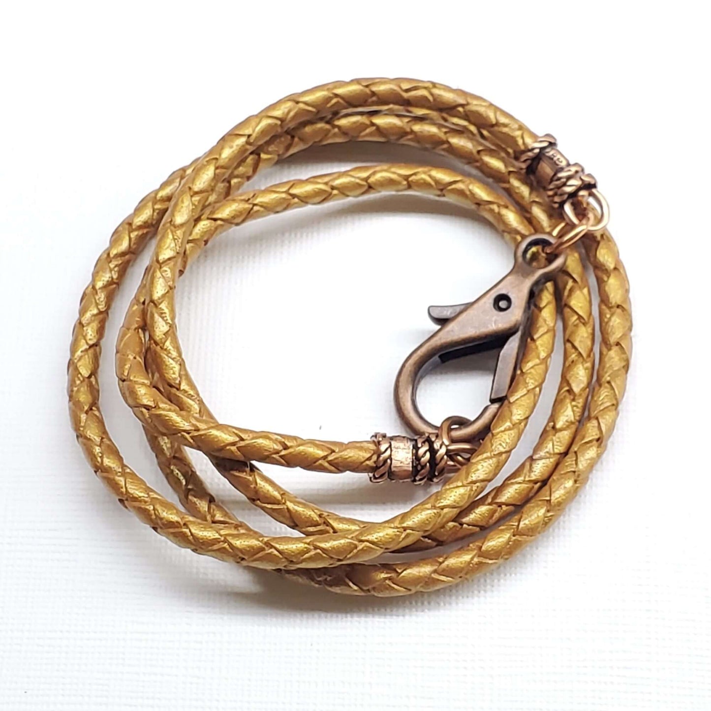 Gold braided leather necklace with clasp on a white background