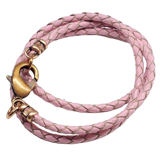 Pink braided leather necklace with gold clasp on a white background