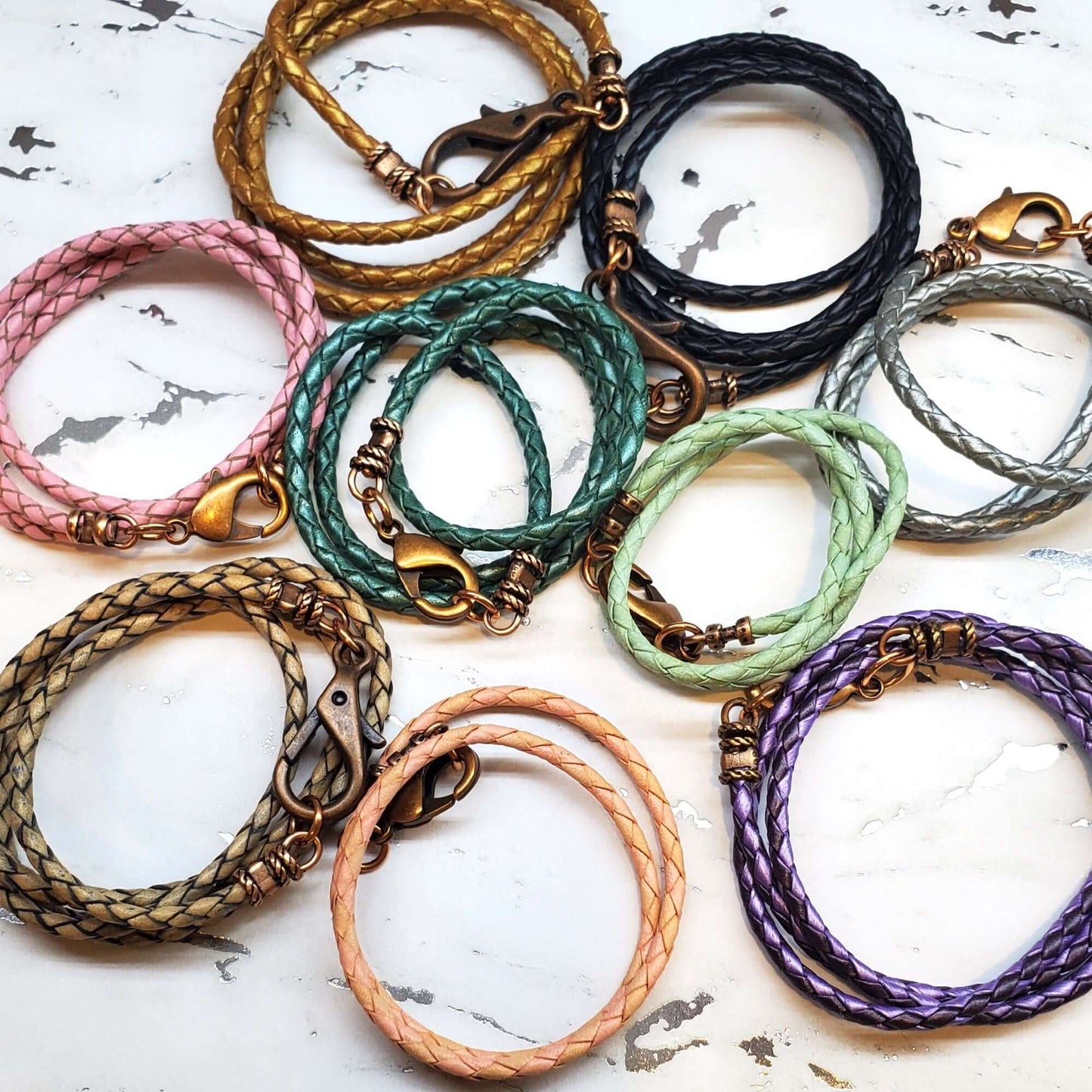 Collection of colorful braided necklaces on a marble surface