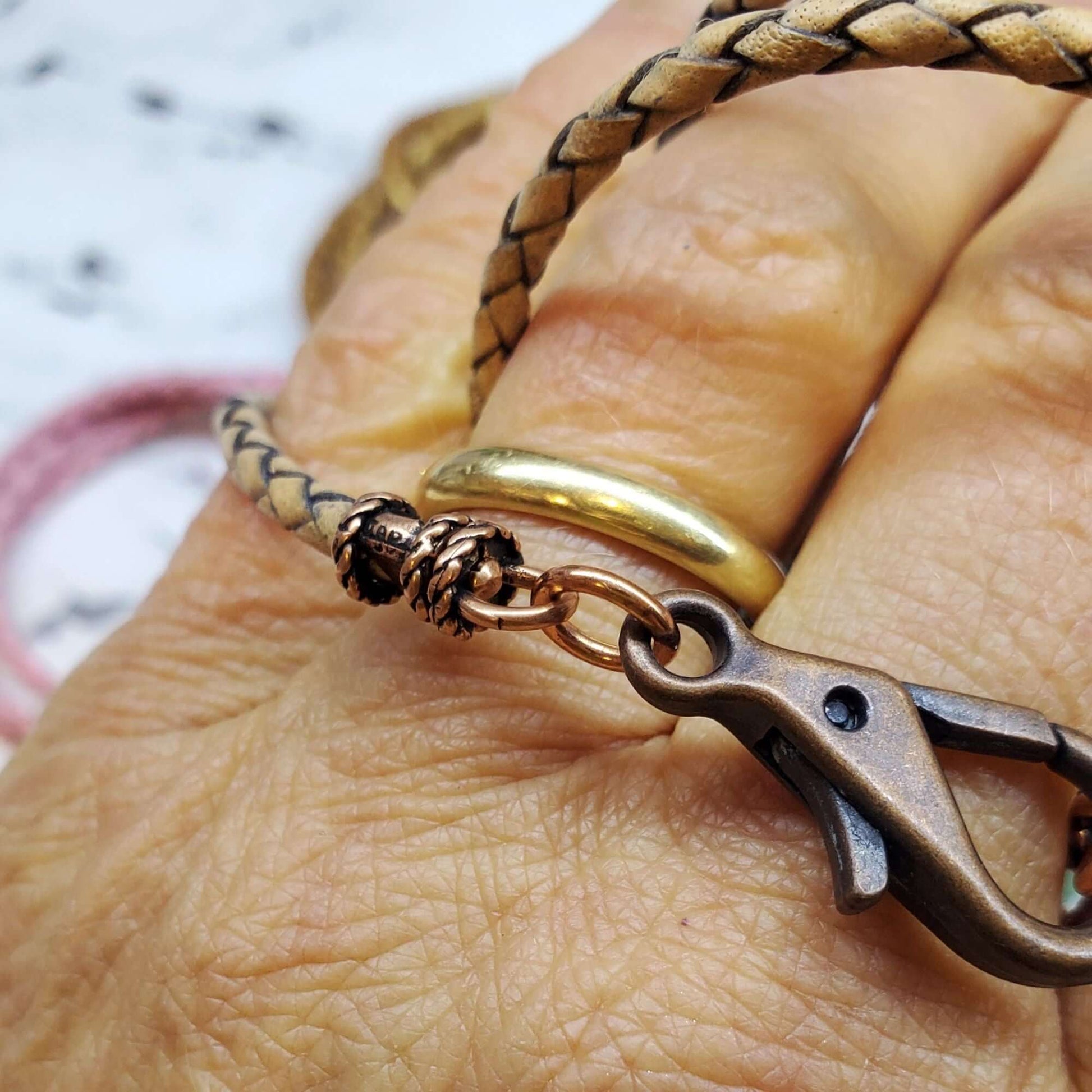 Close-up of a hand holding a necklace with a clasp on a blurred background