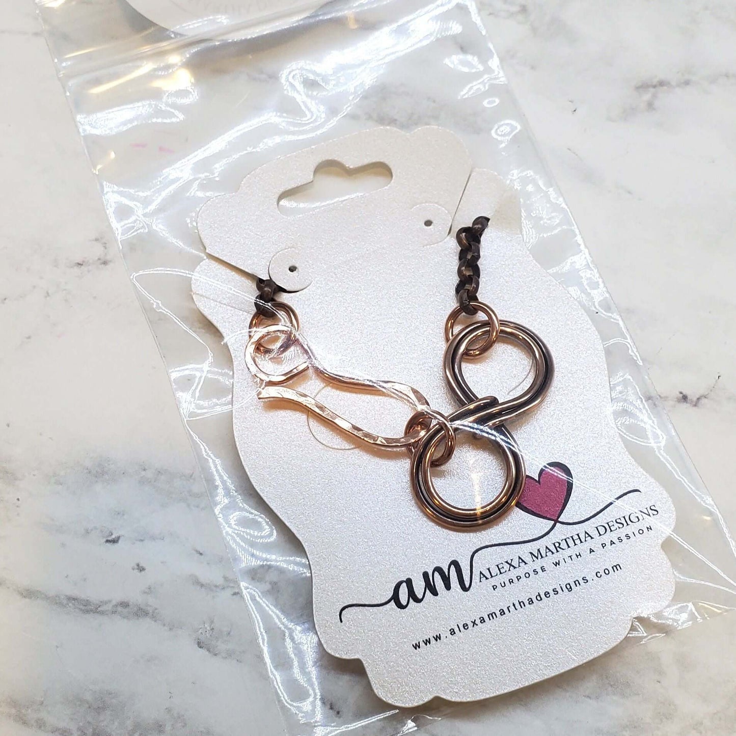Bracelet on a branded card with 'Alexa Martha Designs' on a marble surface