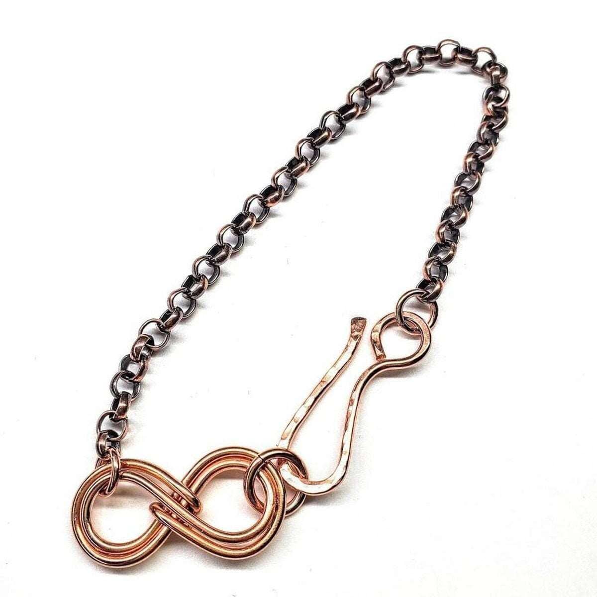 Bracelet with rose gold infinity symbol and black chain on a white background