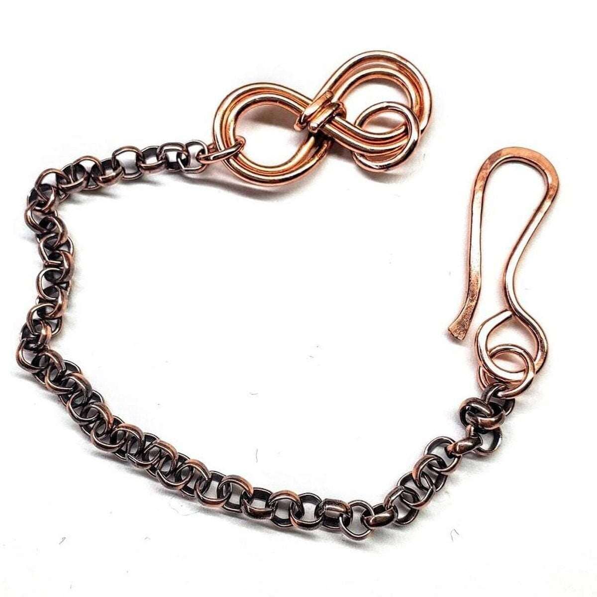 Copper chain bracelet with a bow-shaped clasp on a white background