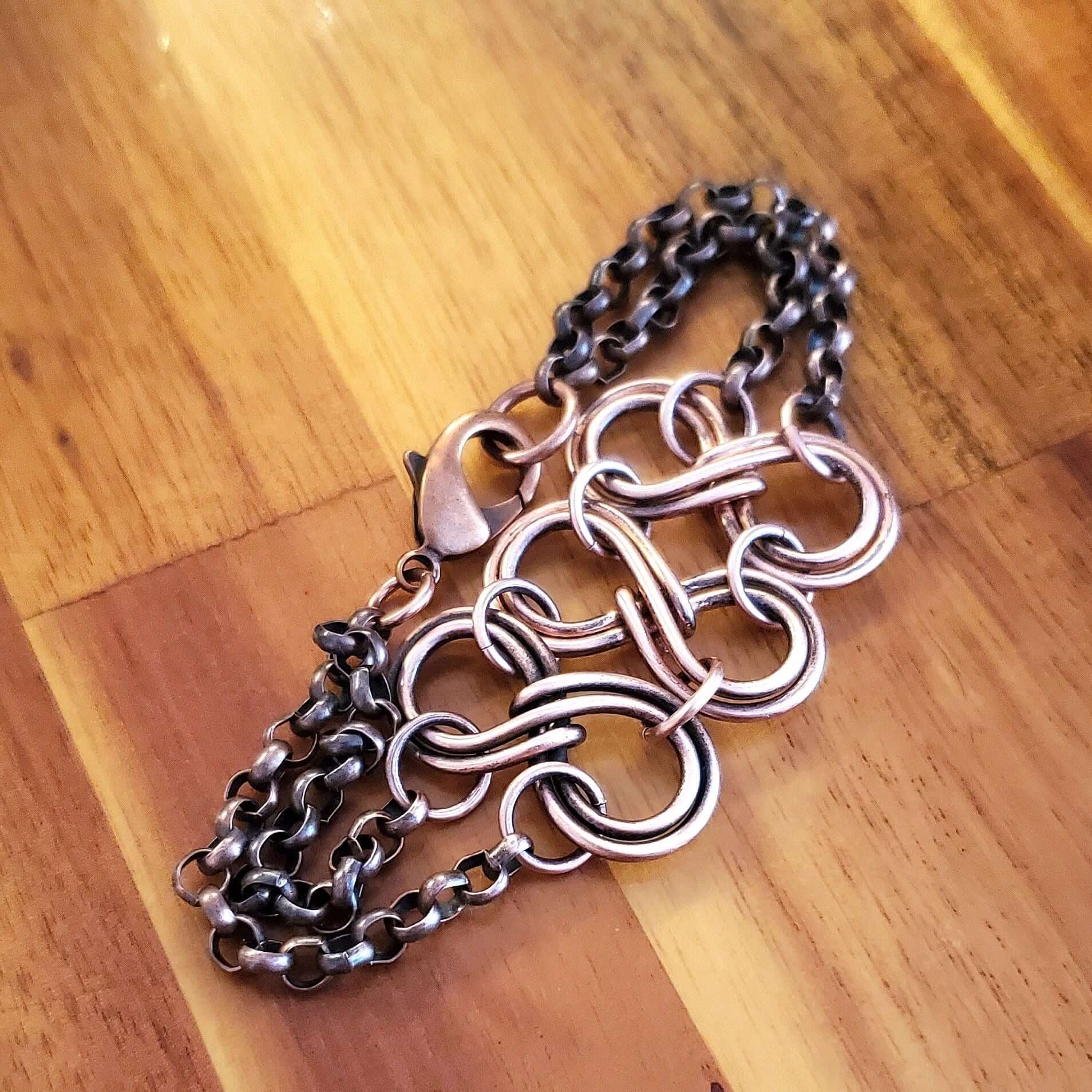 Metallic chain necklace on a wooden surface