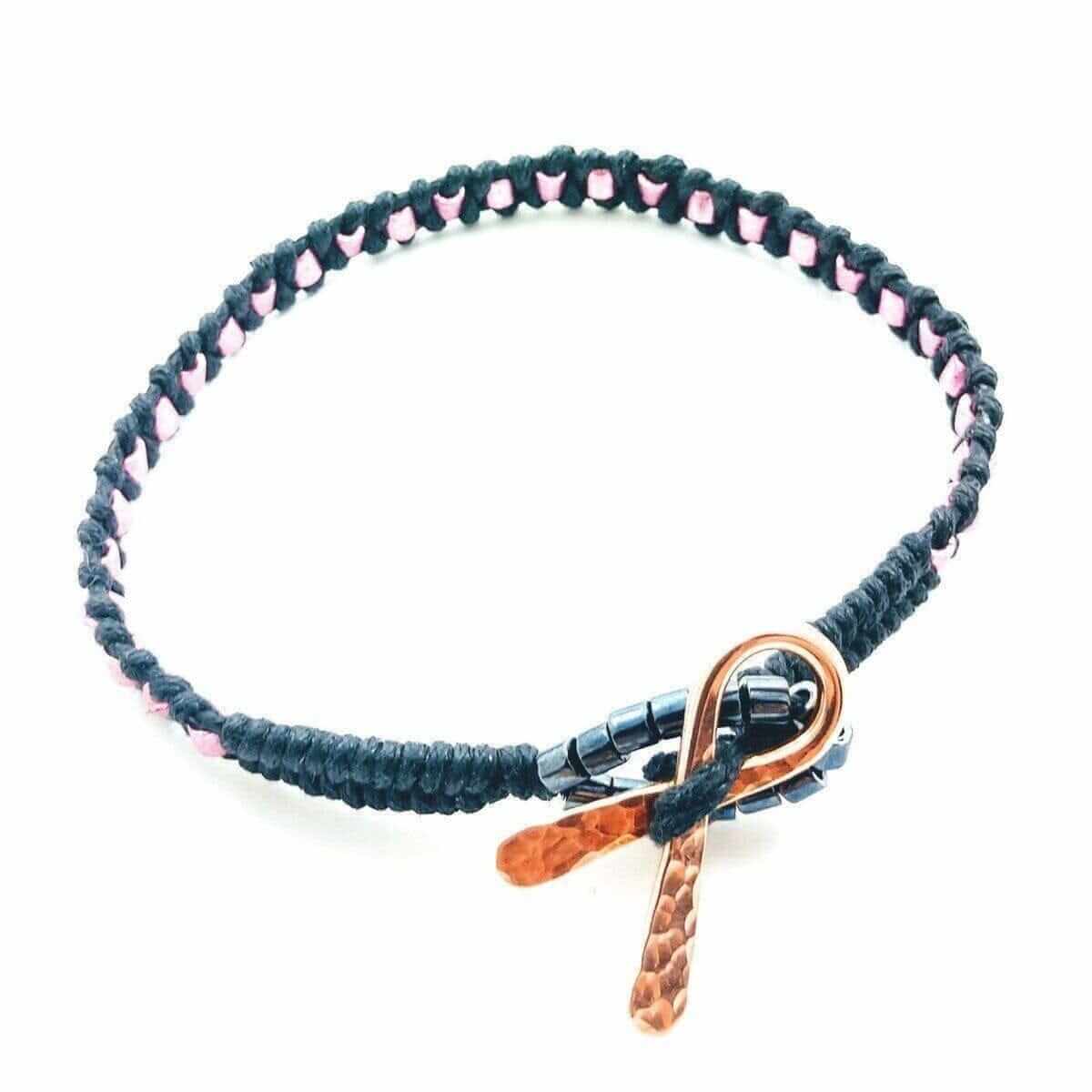 Bracelet with black cord and rose gold clasp on a white background
