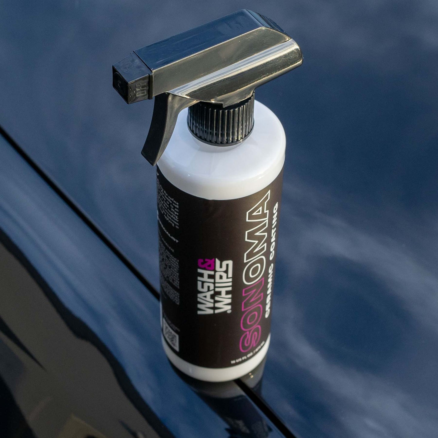 Spray bottle with 'Wash & Wax' branding on a reflective surface