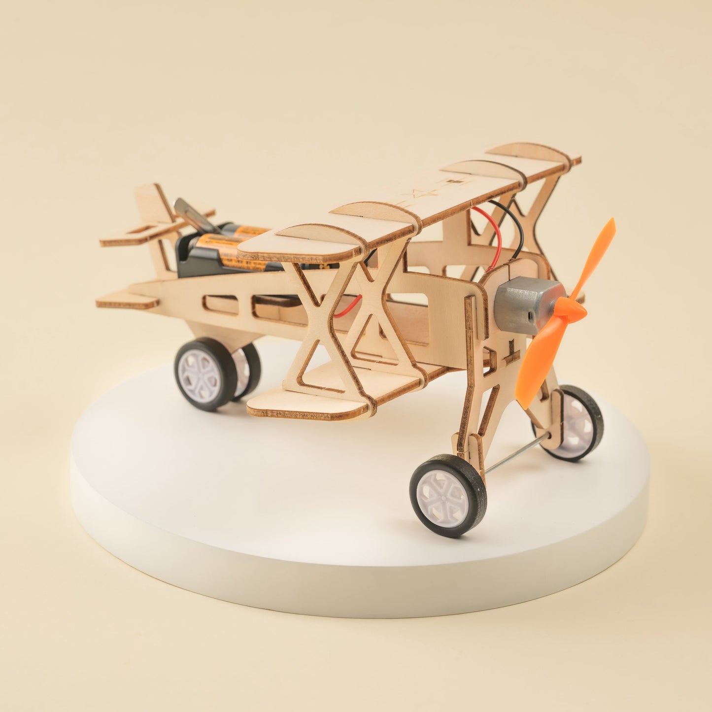 Wooden model airplane on a white base with a beige background