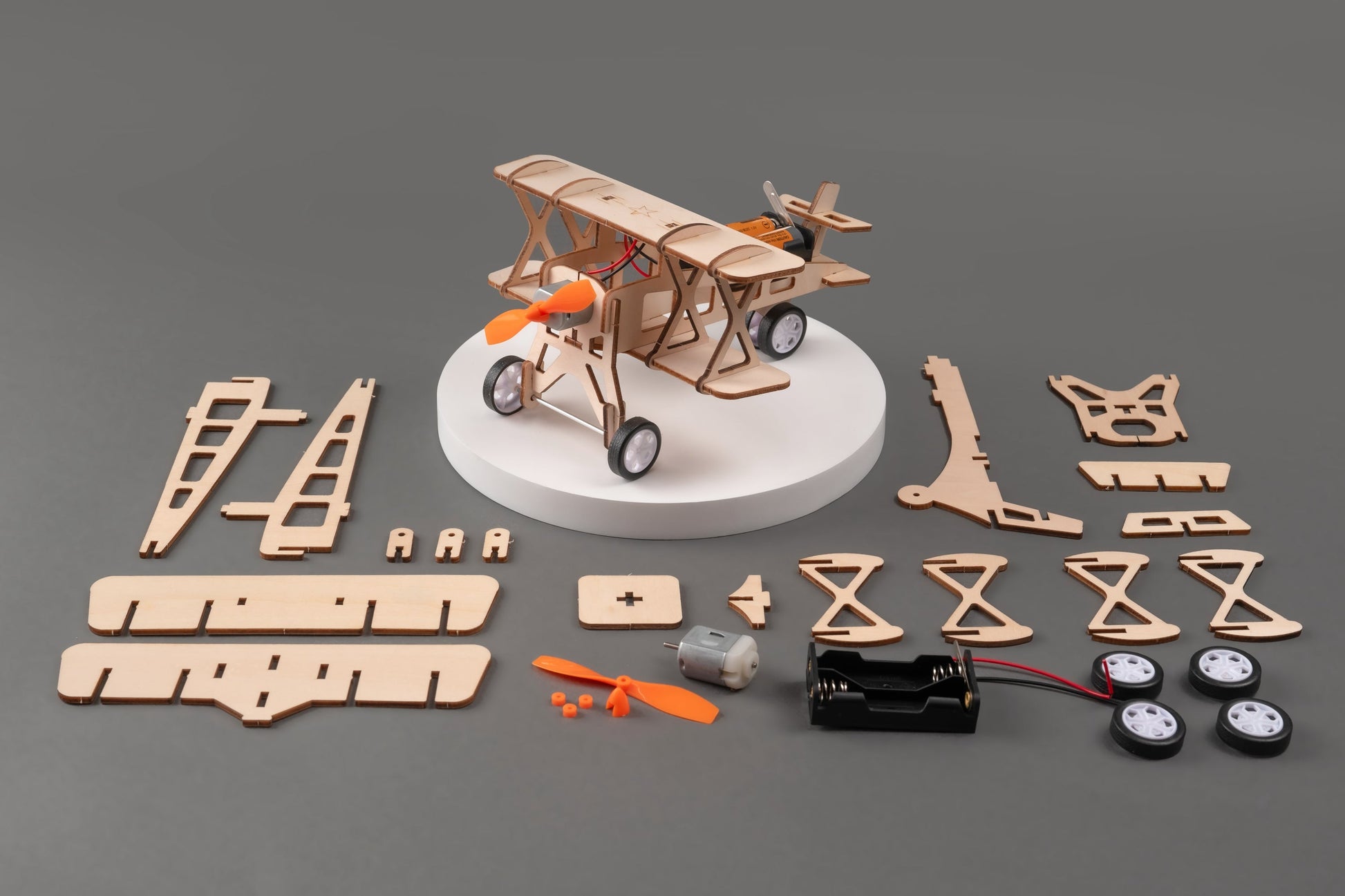 Model airplane kit with unassembled parts on a gray background