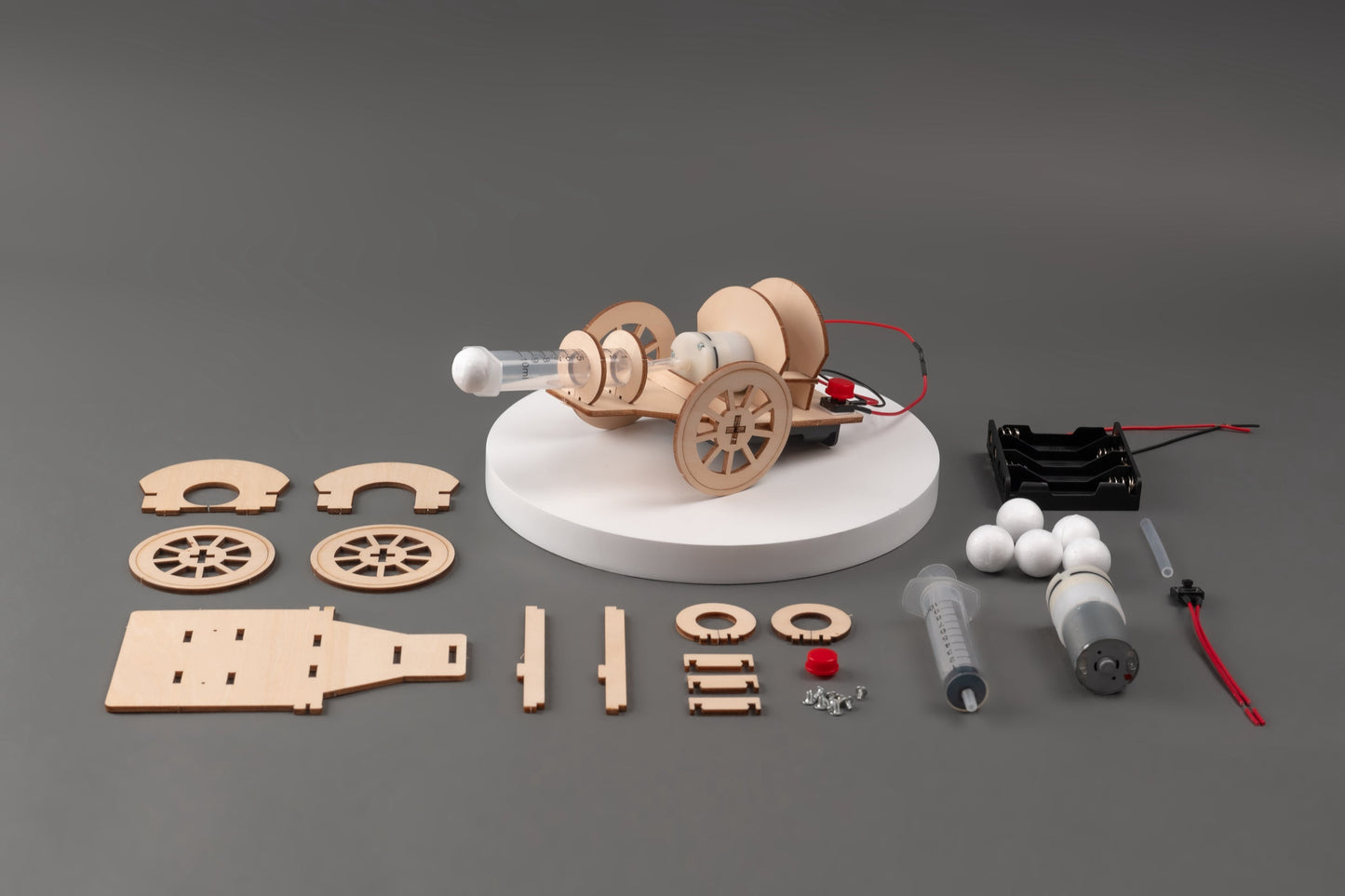 Wooden model car kit with components on a gray background