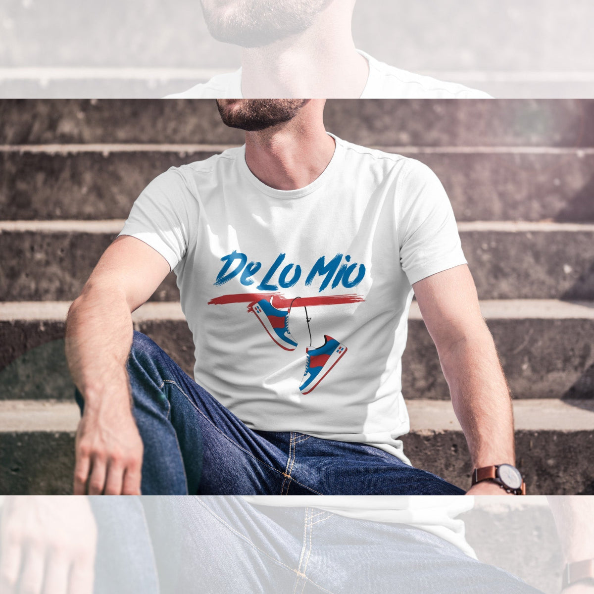 Person wearing a white t-shirt with 'De Lo Mio' design sitting on steps.