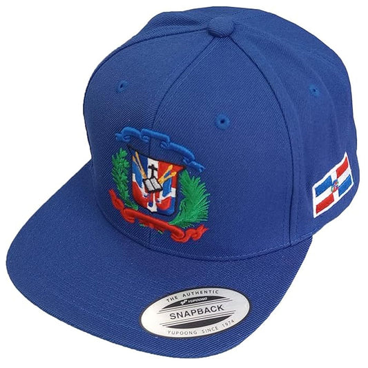 Blue snapback cap with a colorful dominican emblem and brand label on a white background