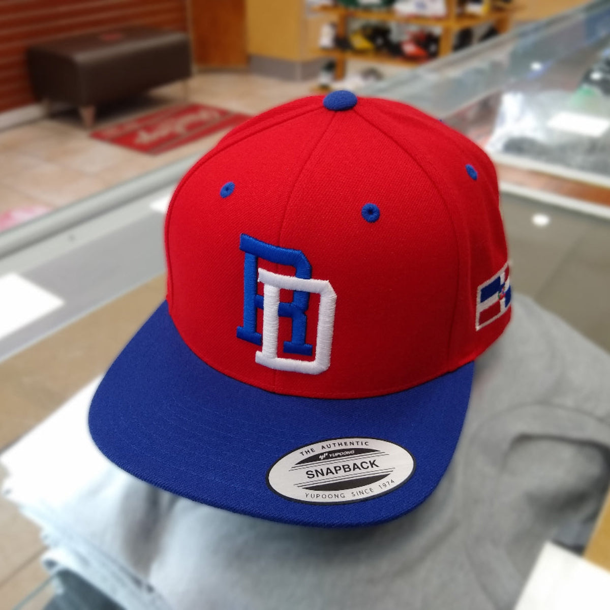 Red and blue cap with a logo on a metallic surface