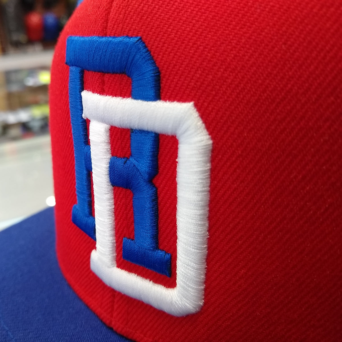 Close-up of a red and blue cap with a  DR logo on a blurred background
