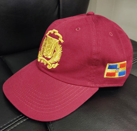 Red cap with yellow emblem and colorful patch on a black leather surface