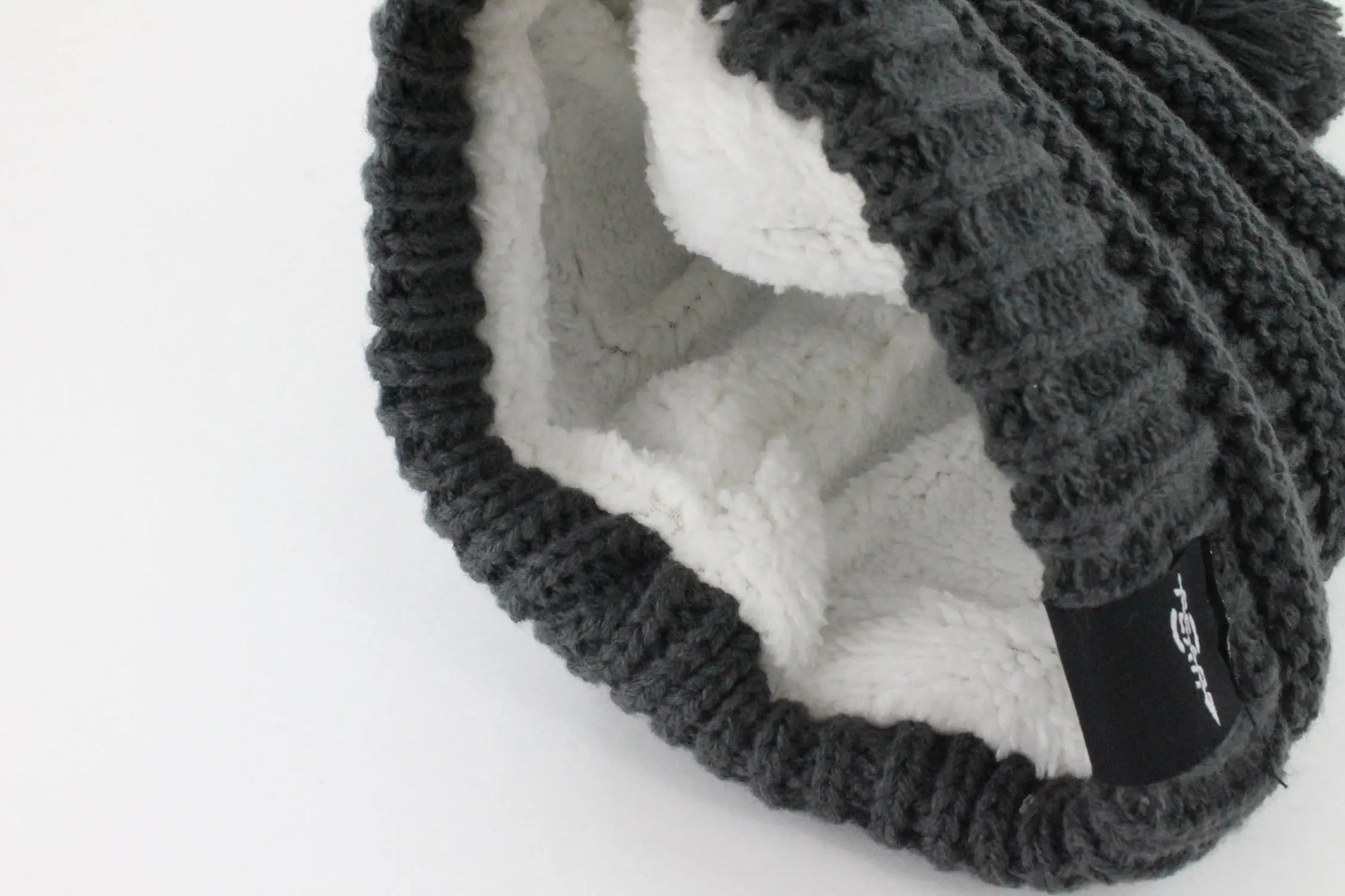 Knitted beanie hat with fleece lining on a white background