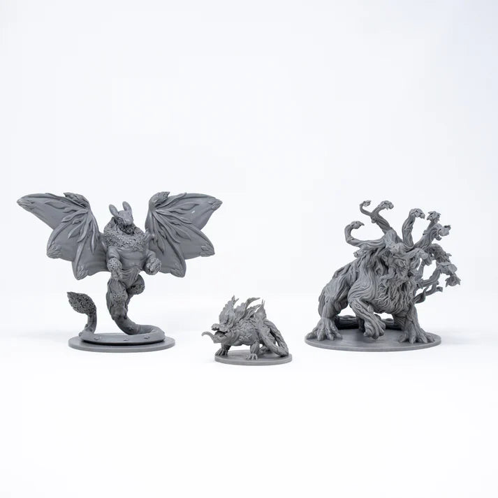 Three gray fantasy creature figurines on a white background