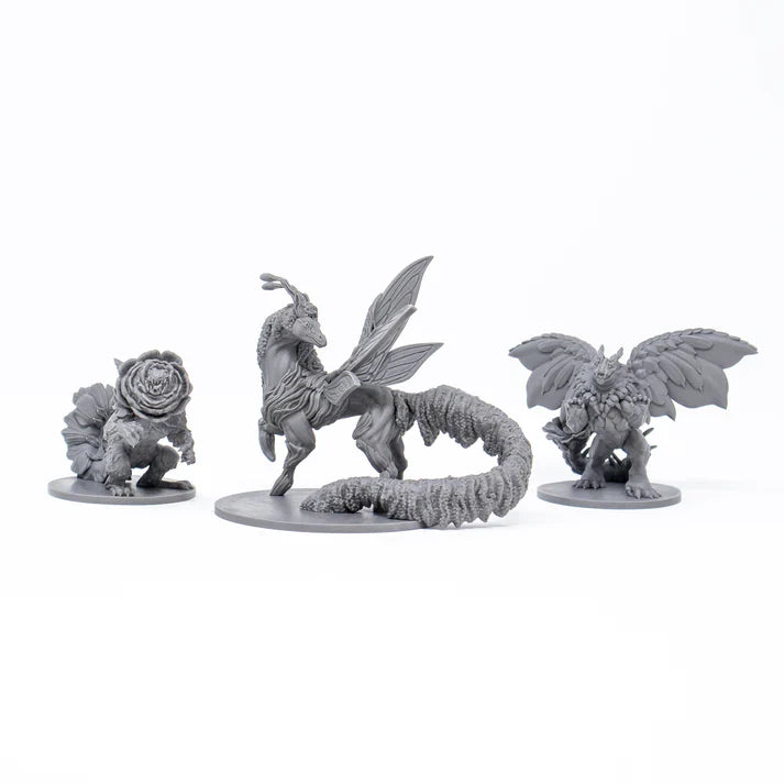 Three fantasy creature figurines on white stands against a white background