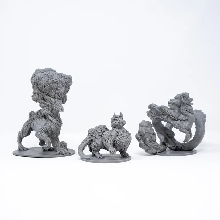 Three gray fantasy creature figurines on a white background