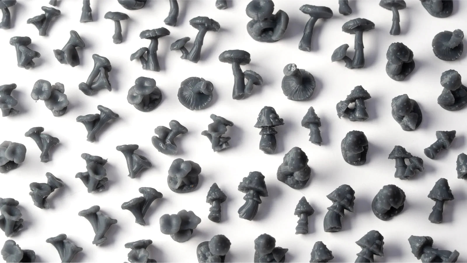 Pattern of small gray mushroom figurines on a white background