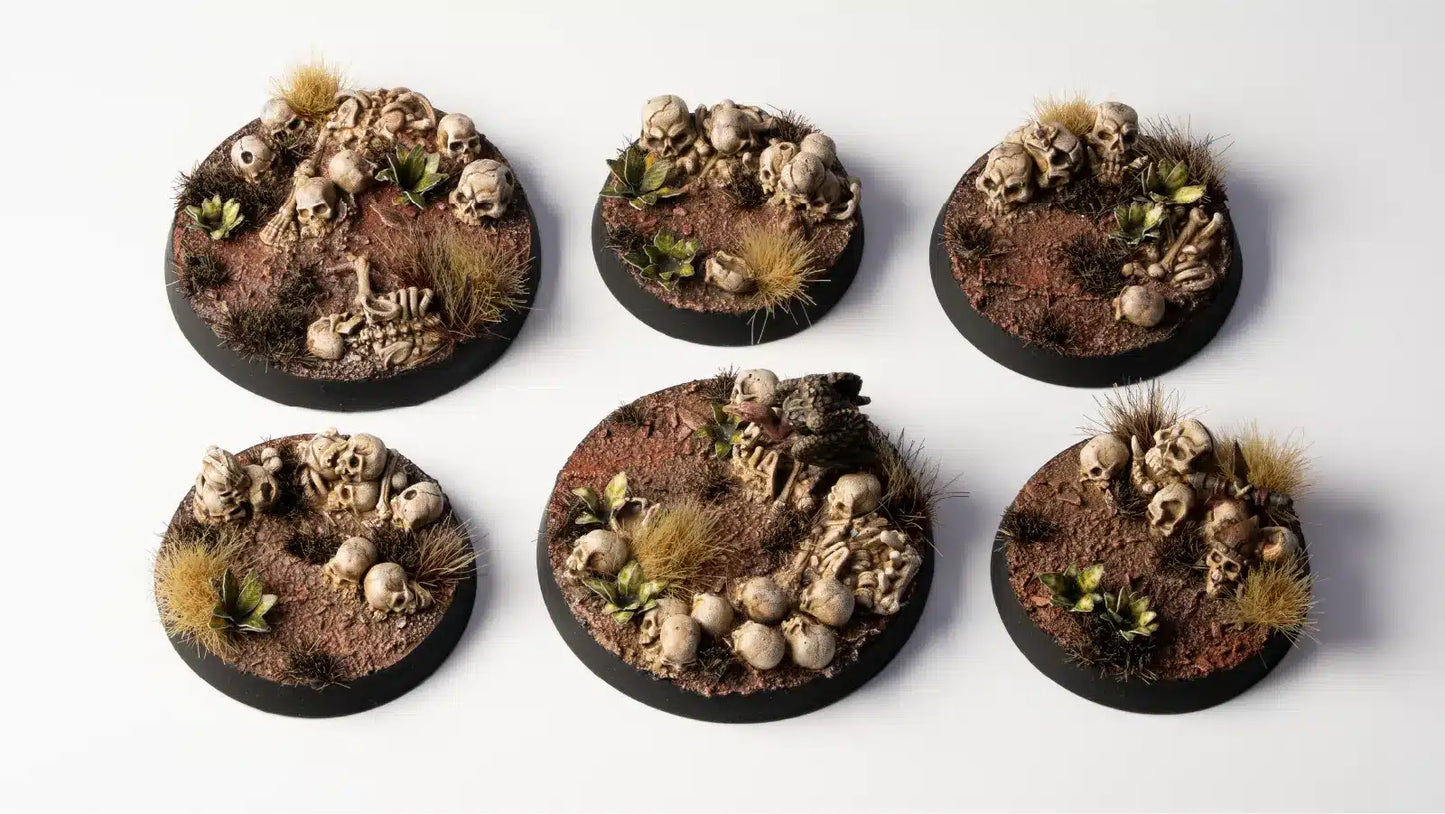 Six round miniature bases with detailed scenery on a white background