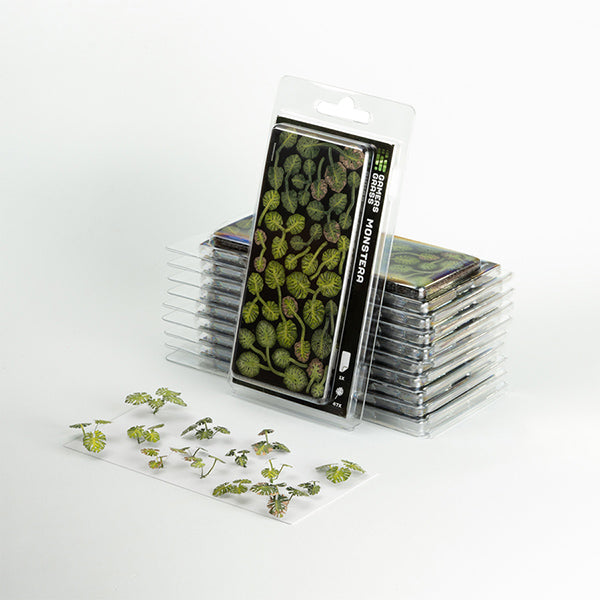 Stack of transparent plastic cards with green plant samples on a white background