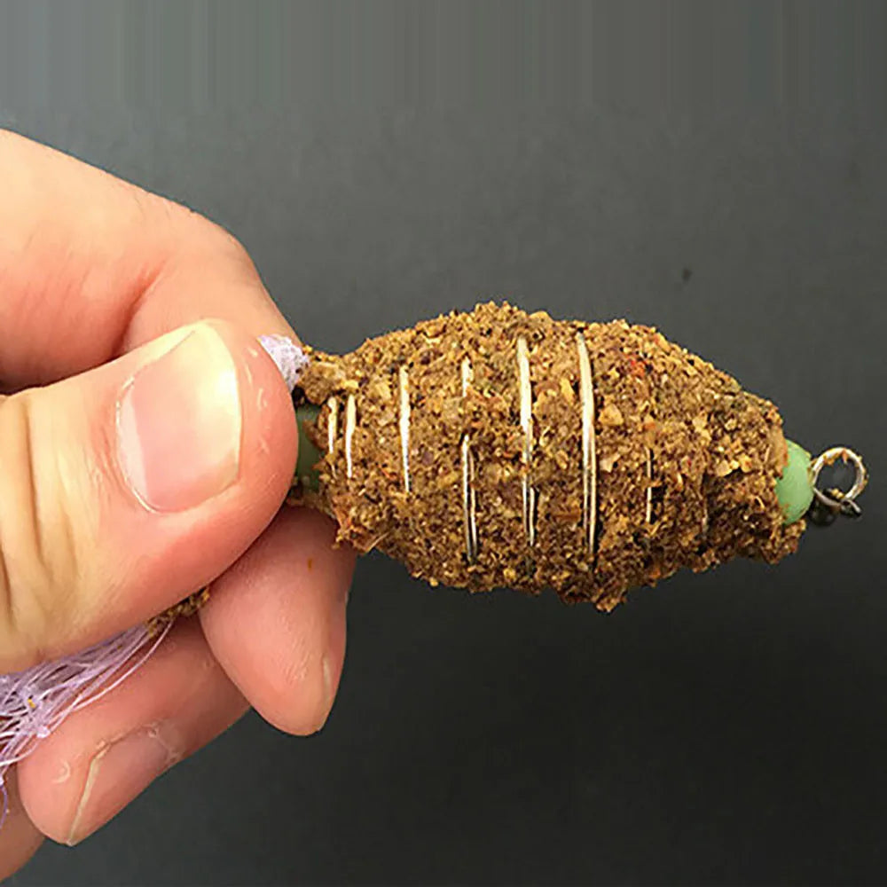 Fishing lure held by a hand against a dark background