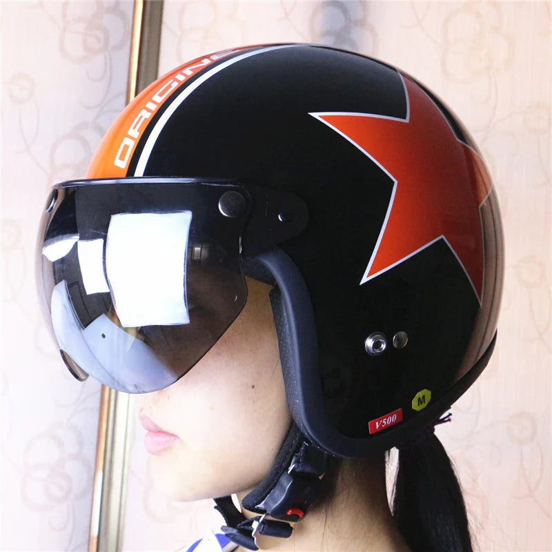Black helmet with orange star design and visors.