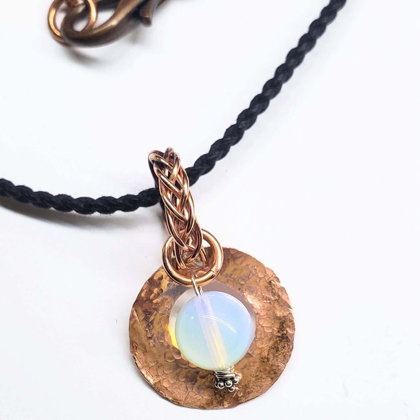 Necklace with a copper pendant featuring an opal stone on a white background