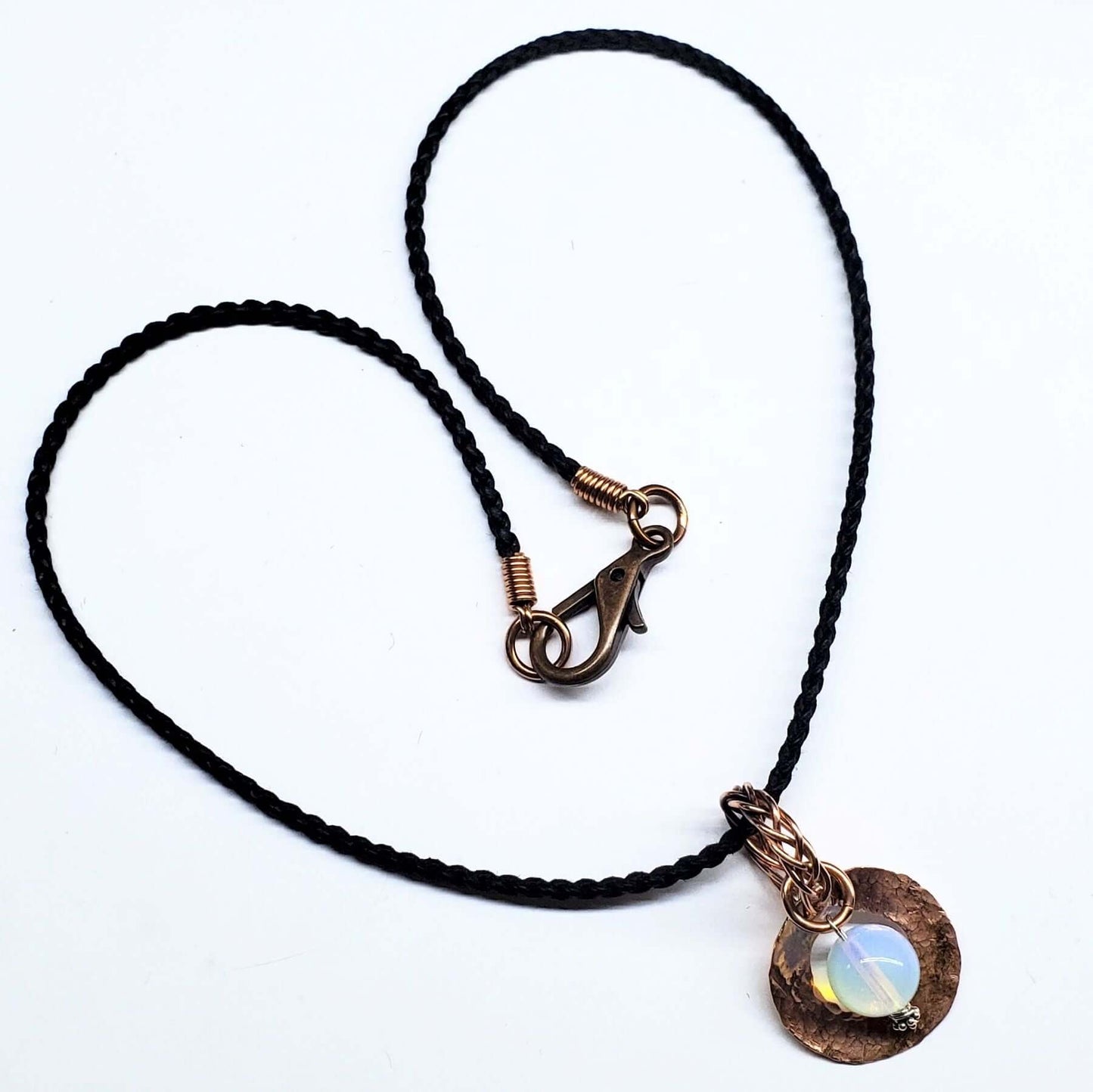 Necklace with black cord and bronze clasp on a white background