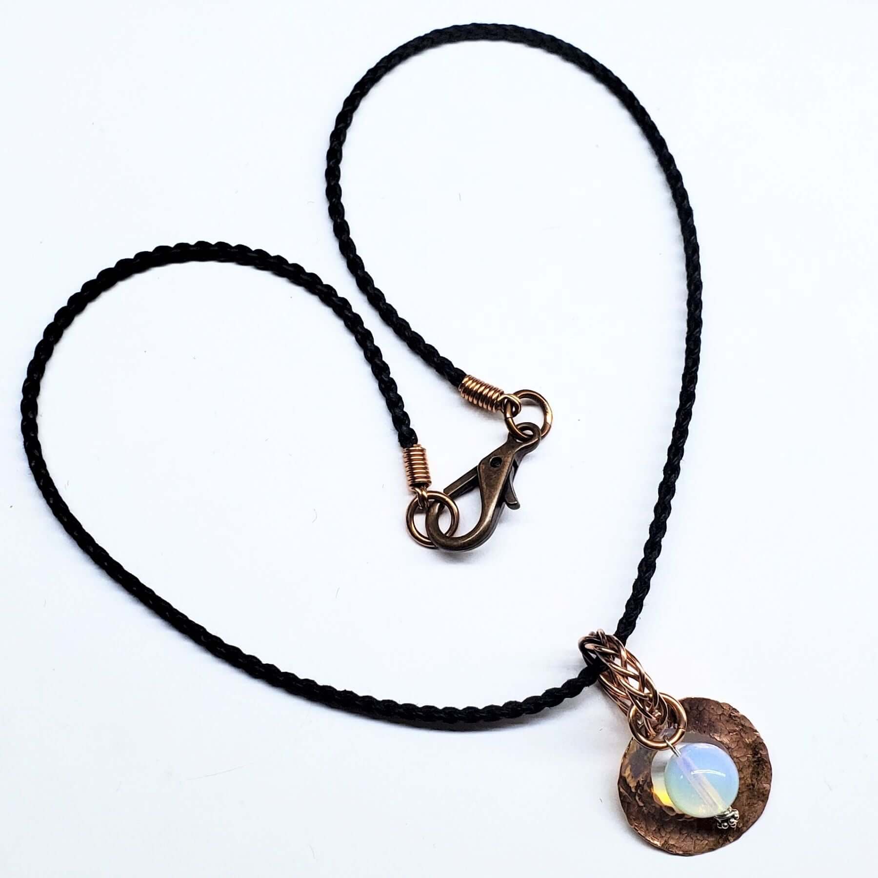 Necklace with black cord and bronze clasp on a white background
