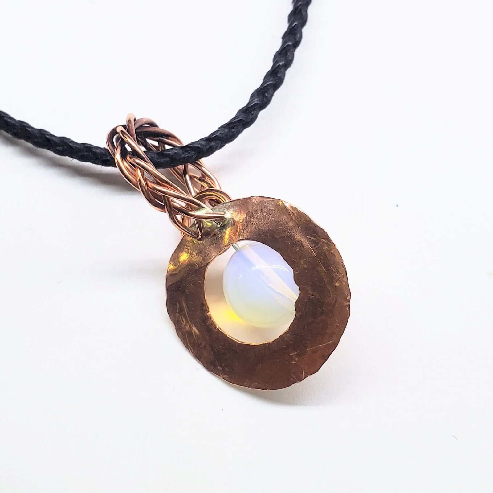 Necklace with a round pendant featuring a white stone on a white background