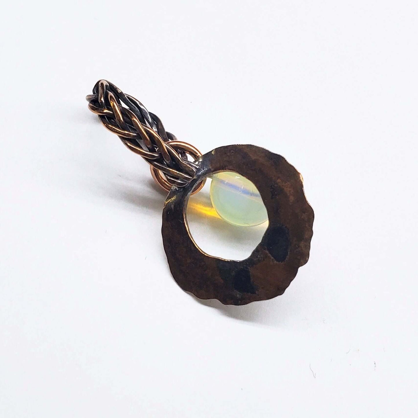 Bronze colored pendant with a central gemstone on a white background