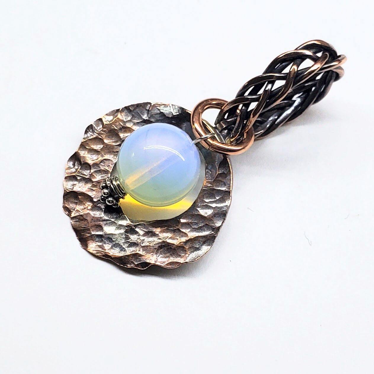 Pendant with liminite stone and braided design on a white background