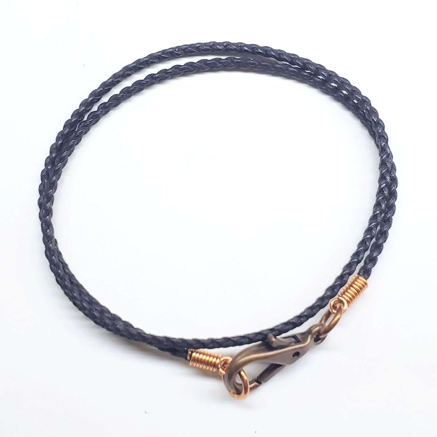 Navy braided leather bracelet with gold clasp on a white background