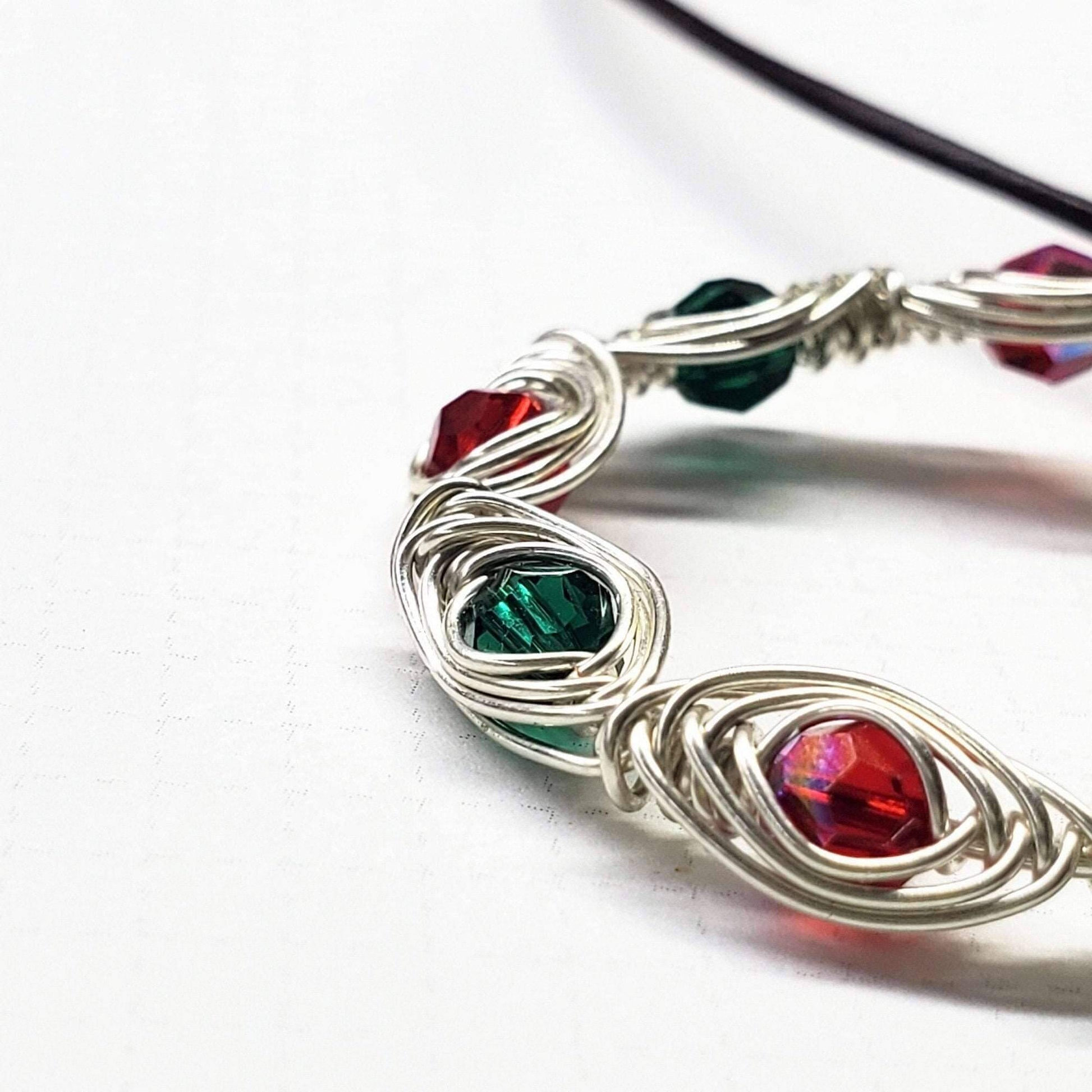 Pendant with red and green gemstones on a white background