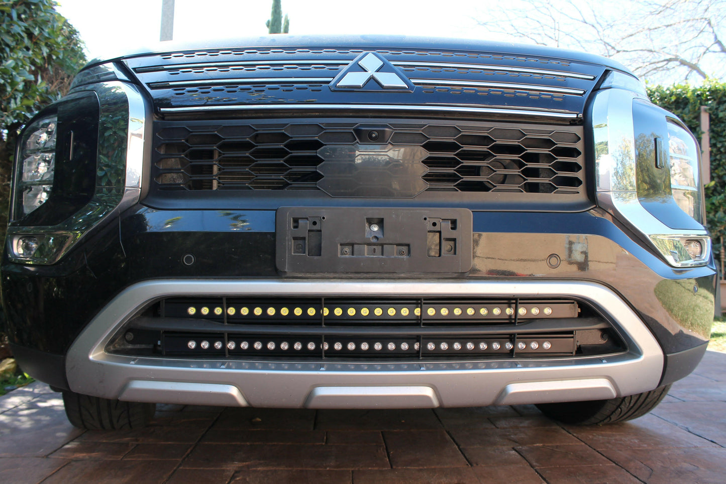 Front view of a black Mitsubishi truck with visible logo and LED Light Bars