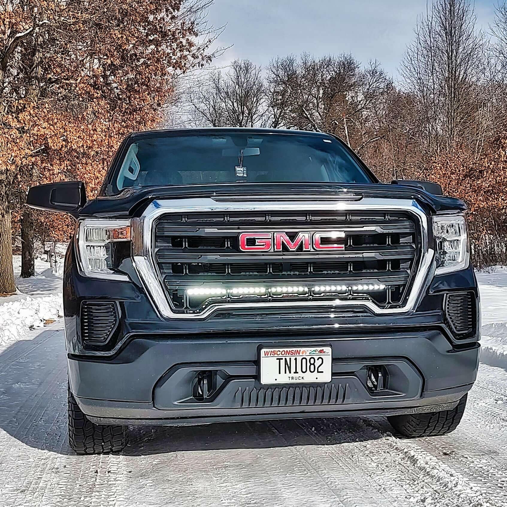 GMC truck with LED Light Bar in a snowy landscape with trees in the background