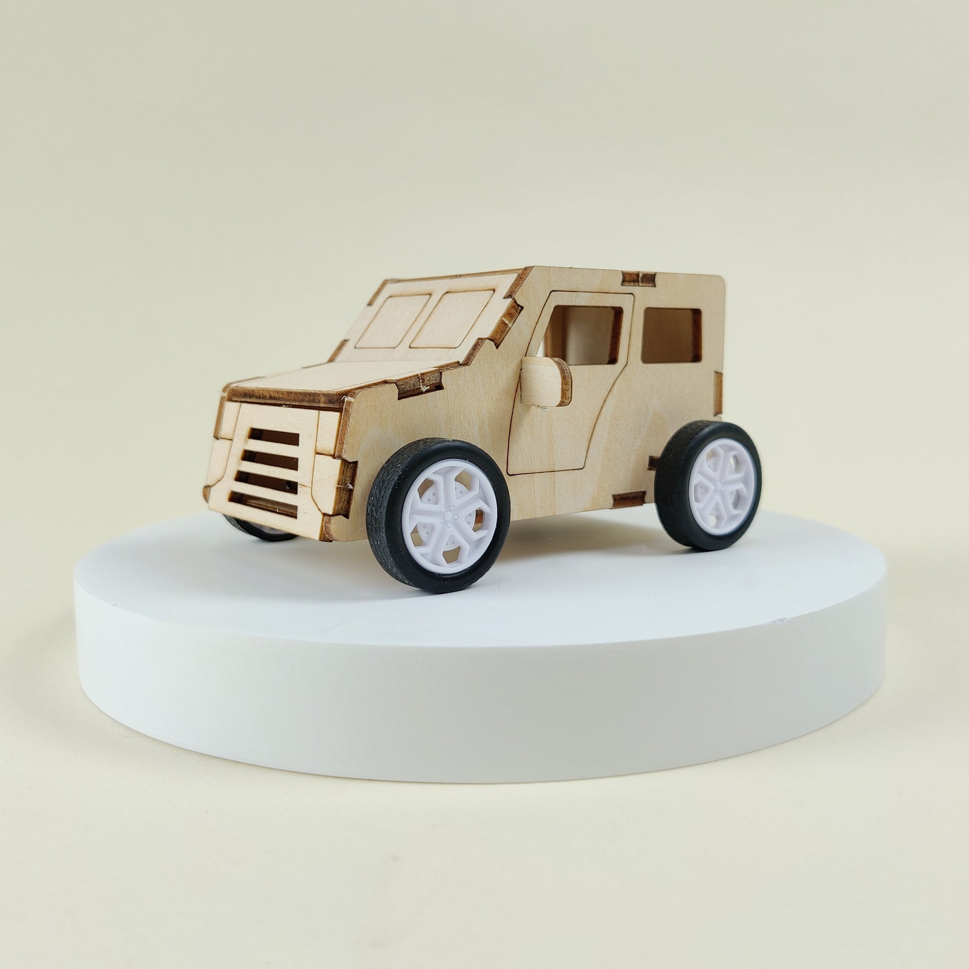Wooden model of a vehicle on a white platform with a beige background