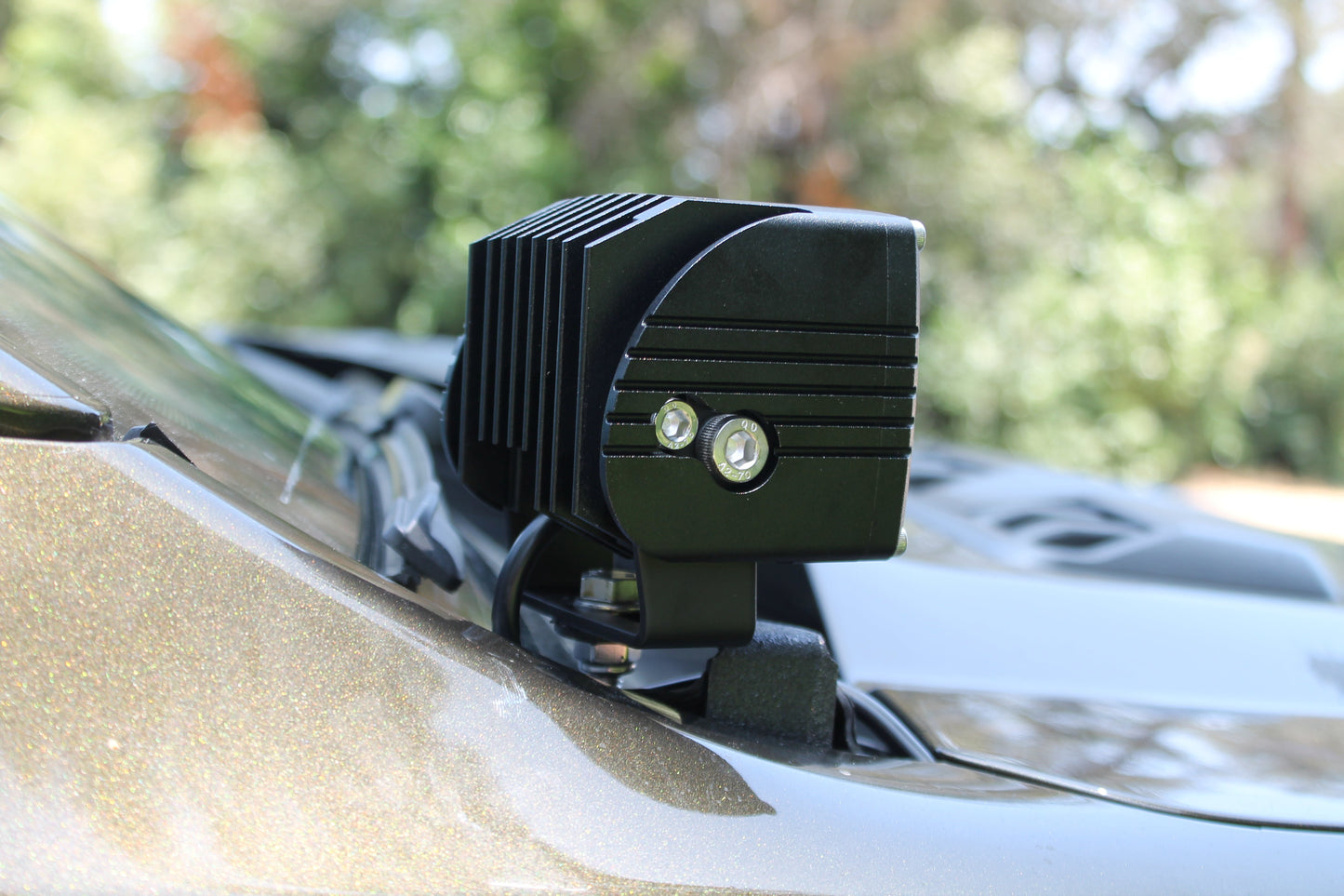 LED light bar mounted on a car roof with a blurred natural background