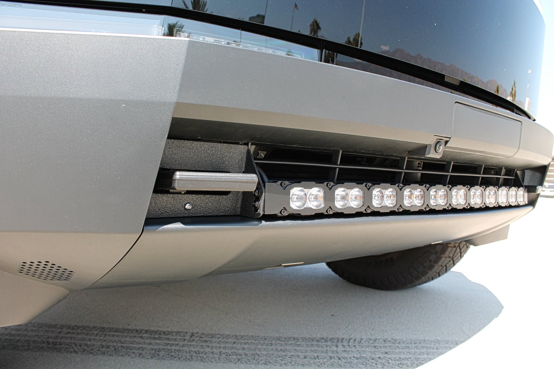 Close-up of a tesla front bumper with LED lights on a snowy road.
