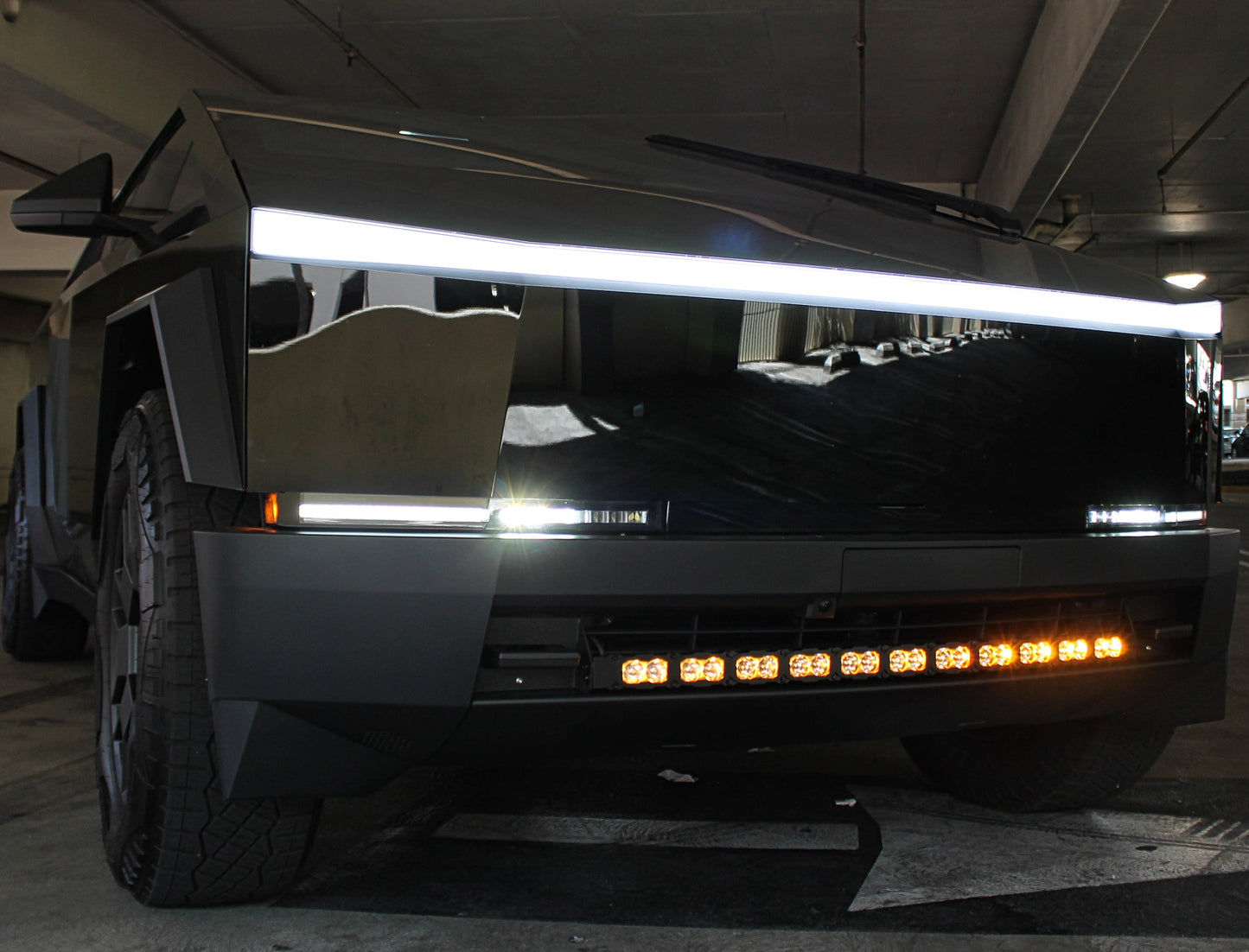 Front view of a futuristic vehicle with prominent headlights and grille in an indoor setting.