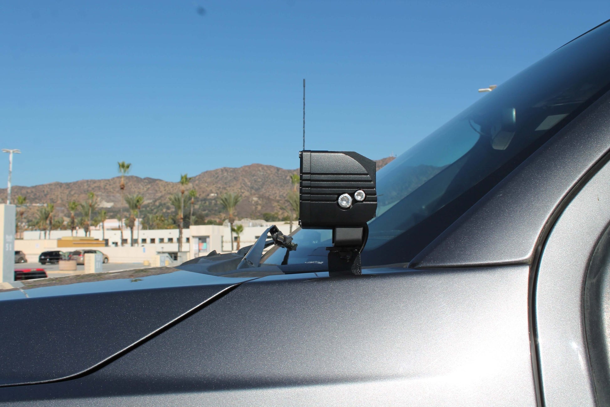 Car with a camera mounted on the windshield in a parking lot.