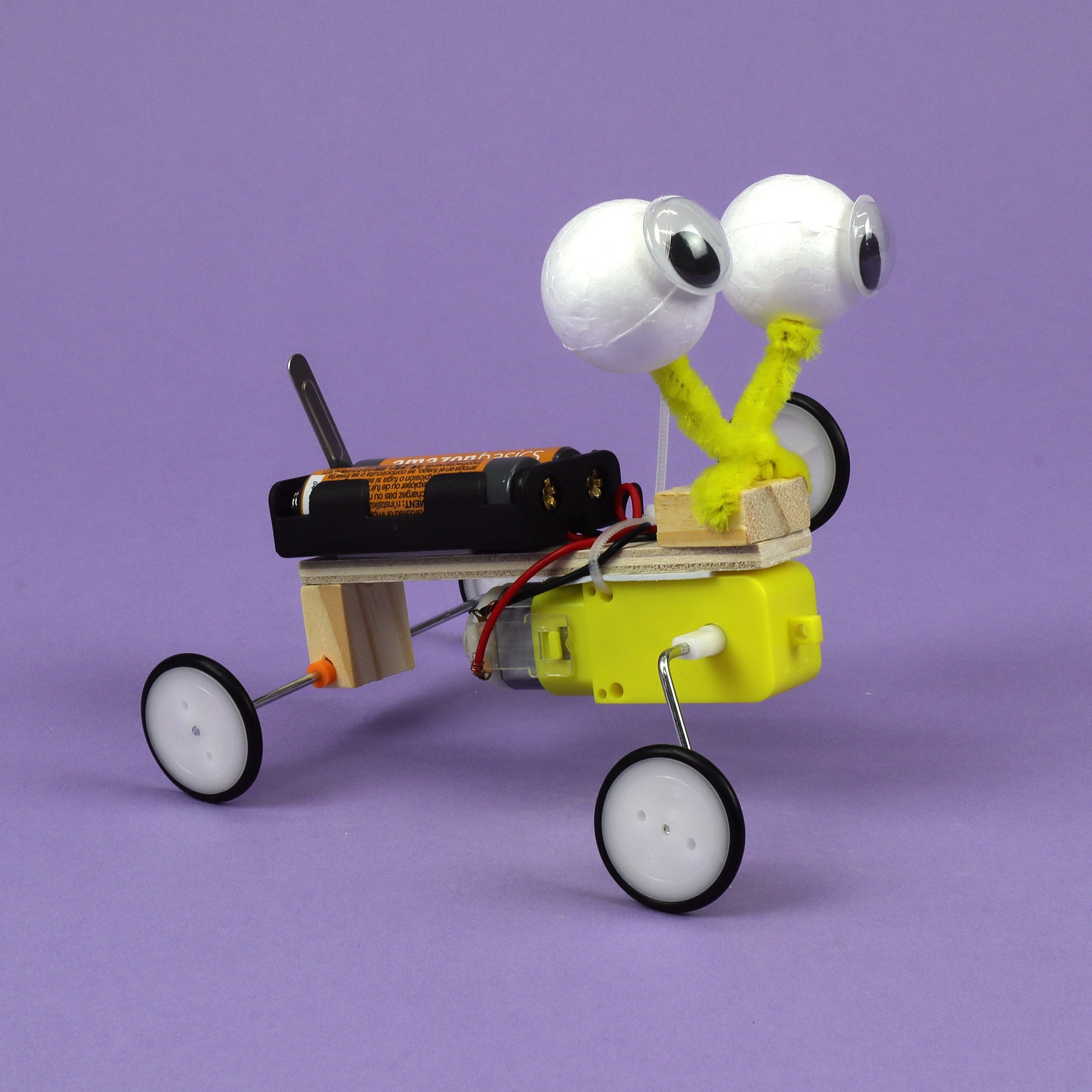 Small robot with googly eyes on a purple background