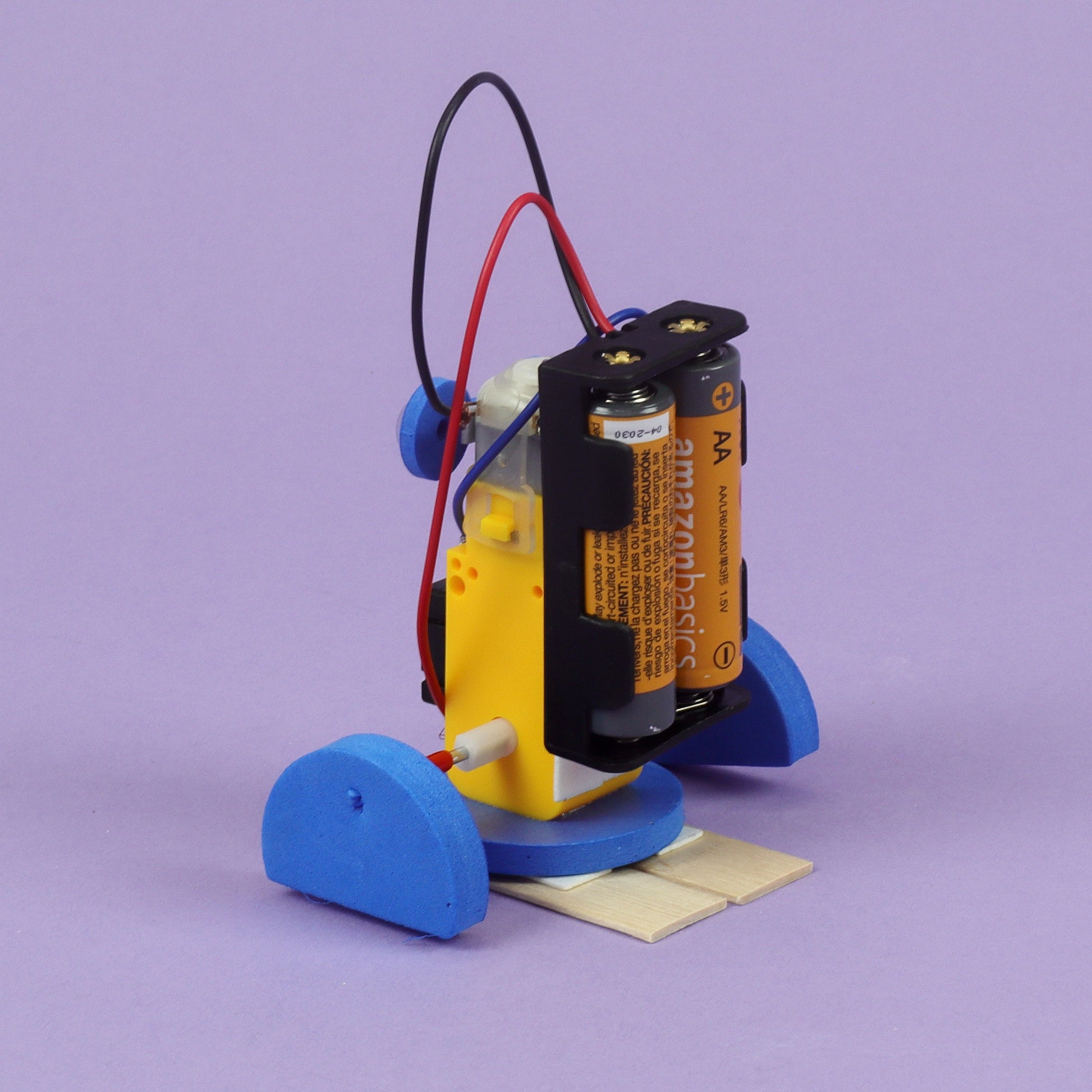Small robot or automation device with batteries on a purple background