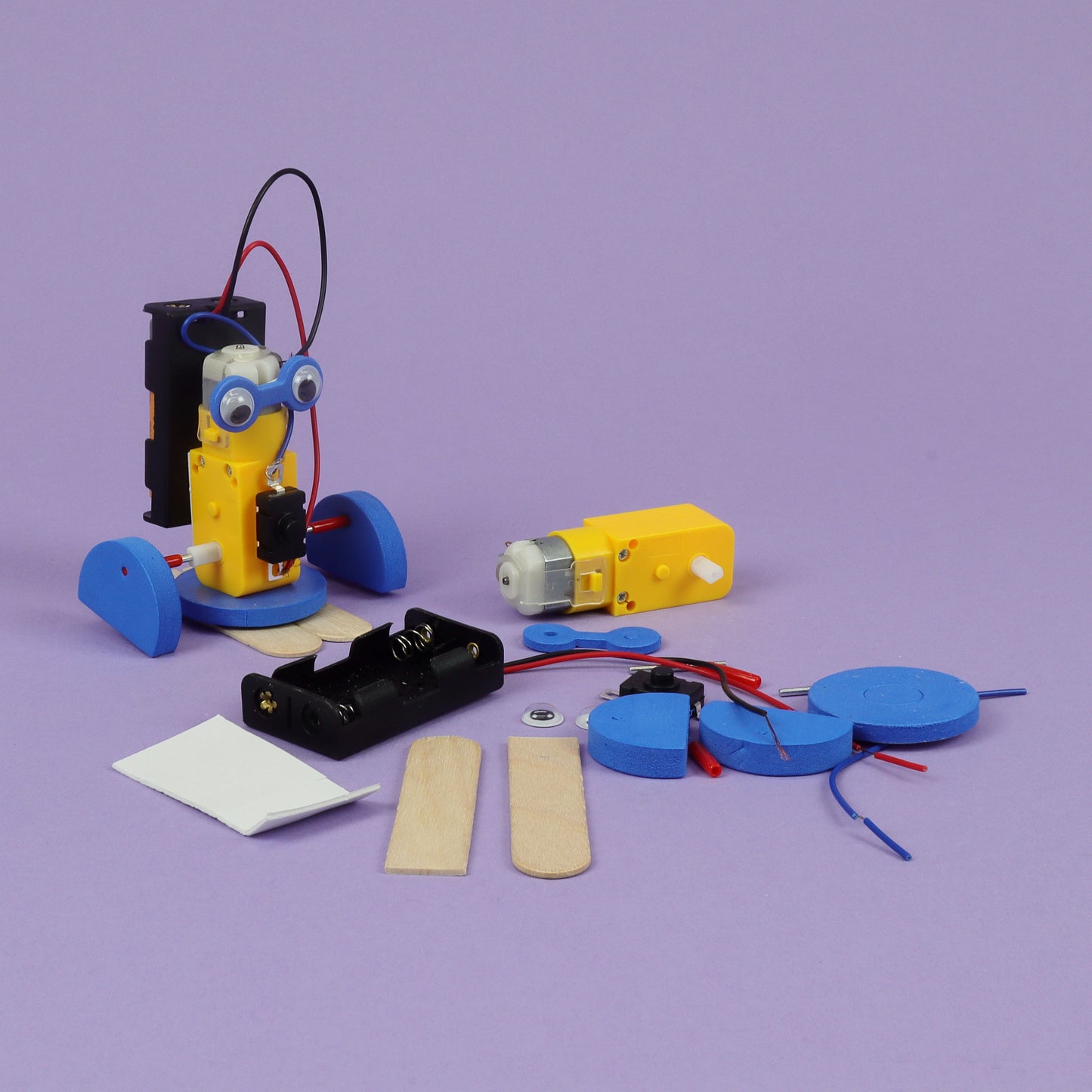 Educational robotics kit with components on a purple background