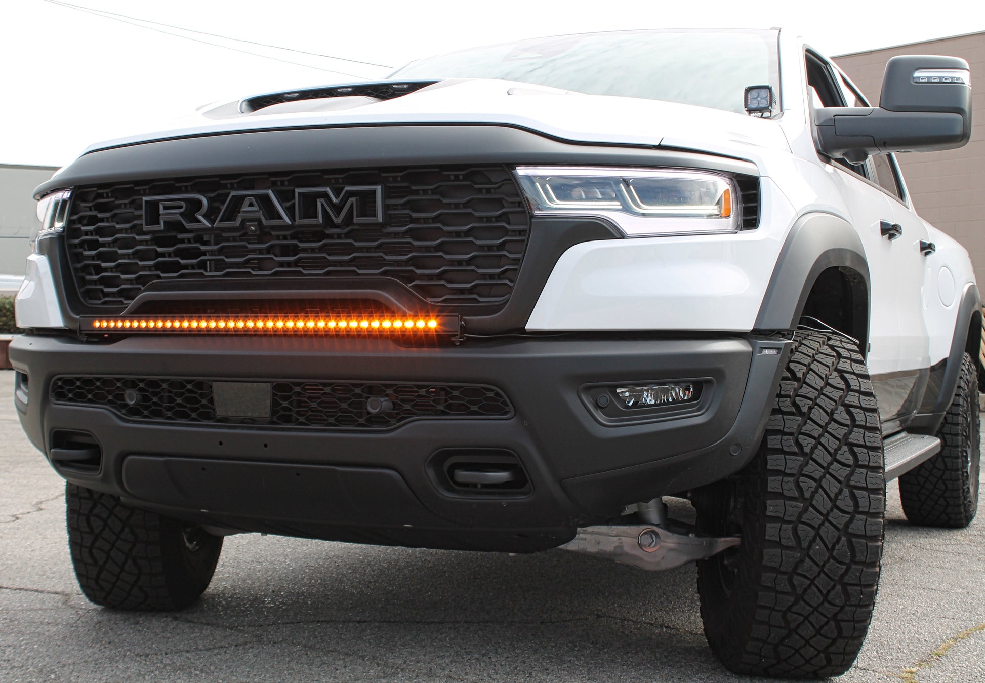 White Ram truck with a prominent front grille and LED light bar.