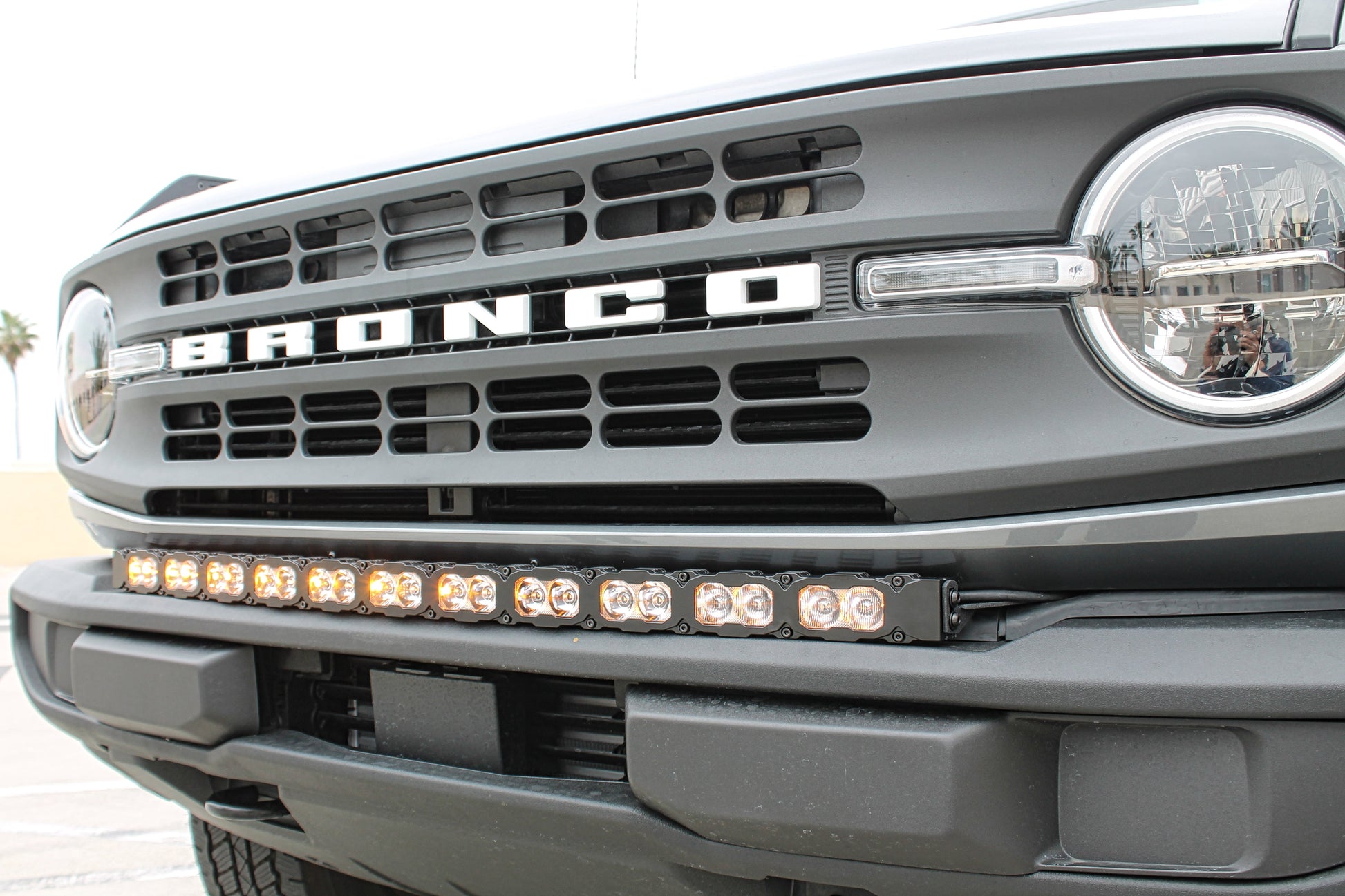 Front view of a Ford Bronco with a prominent grille and LED light bar.